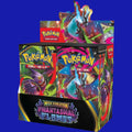 A front view of an open retail display box for the Pokémon TCG Mega Evolution: Phantasmal Flames expansion, showing stacks of individual booster packs inside.